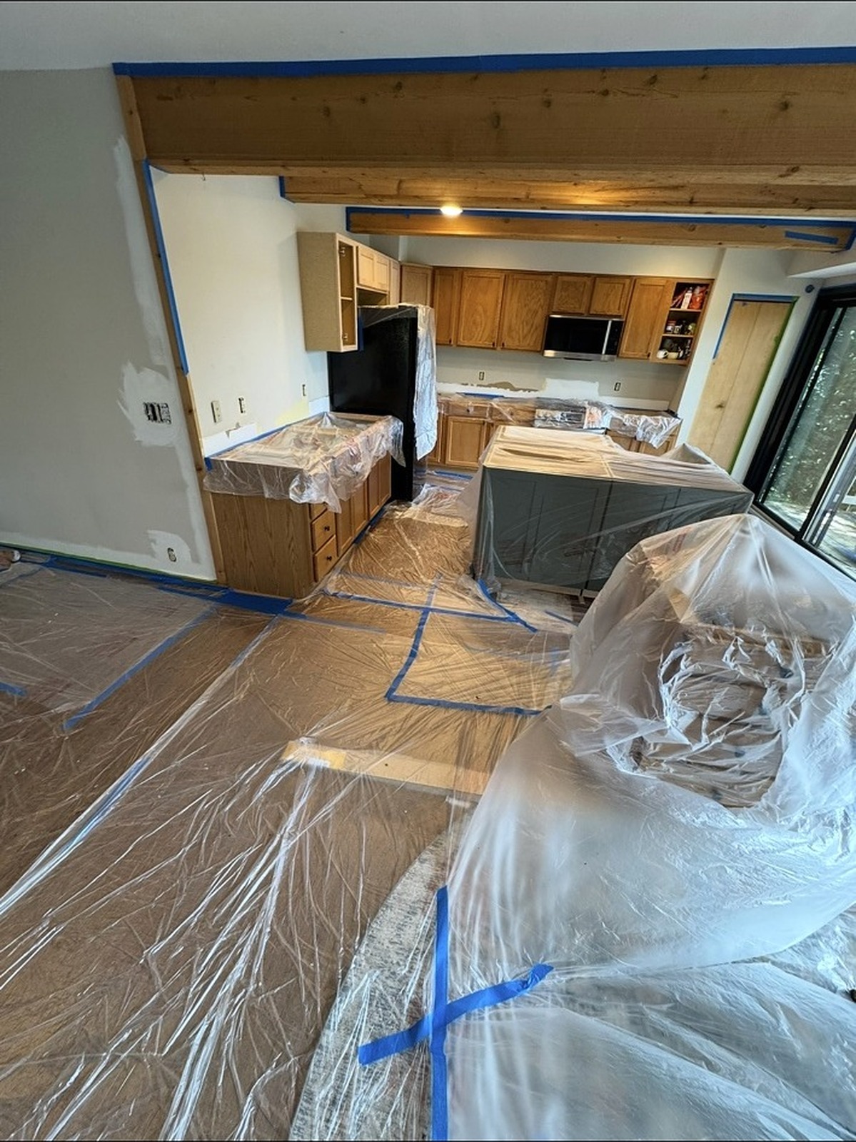 Kitchen cabinets and floors masked off before painting