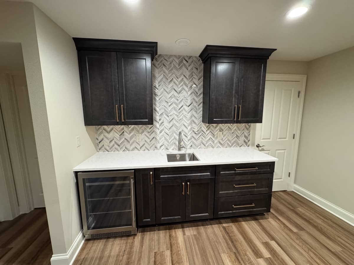 Custom kitchen bar installation with dark wood cabinets and quartz countertop