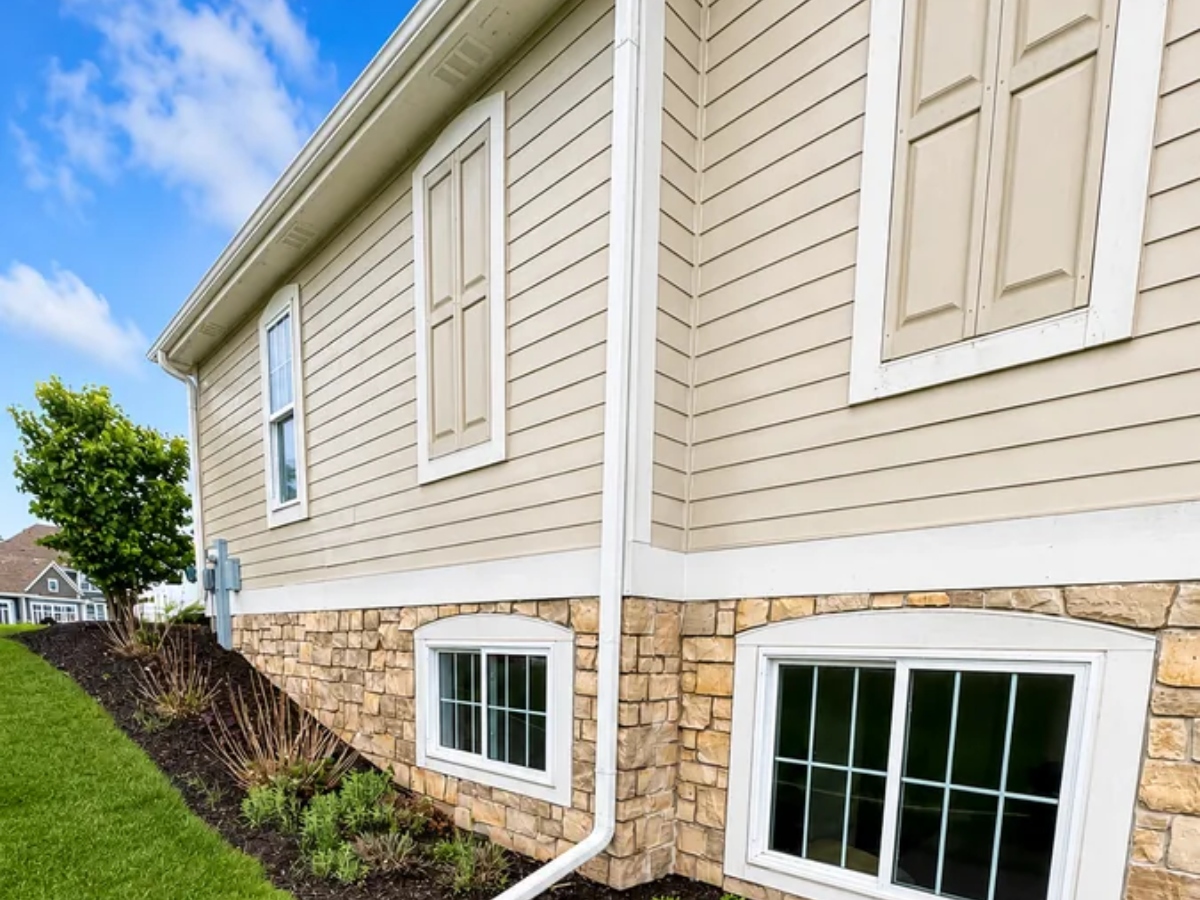 Cream siding home with stone base, freshly painted exterior